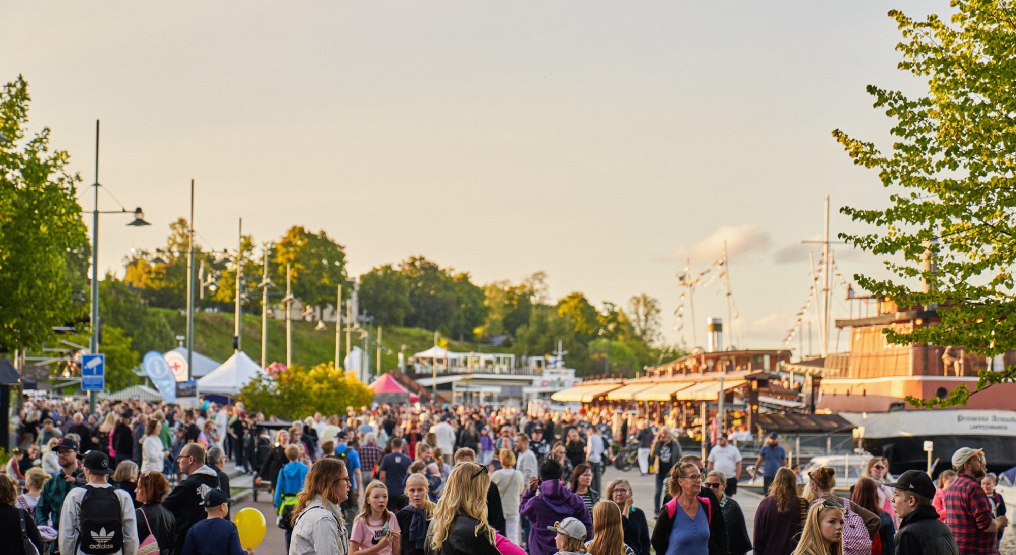 Lappeenrannan satamassa joukko ihmisiä ilta-auringossa.